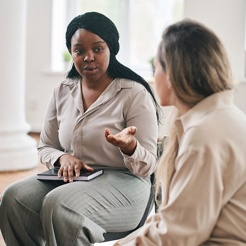 a person talks to a therapist in an outpatient treatment addiction program