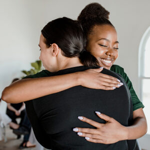 two people embrace with a hug after learning more about sanative recovery and its addiction treatment programs and how they can help