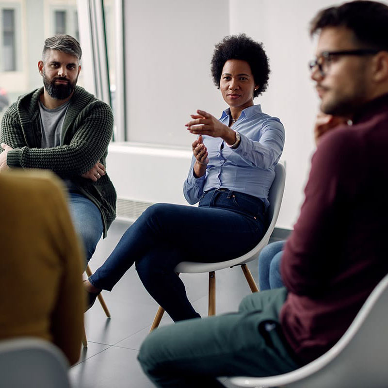 a group of people talk while in a circle at outpatient alcohol treatment