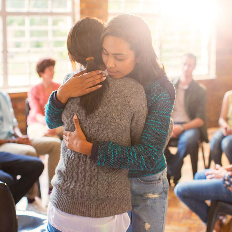 two people hug in an outpatient mental health treatment program in Atlanta